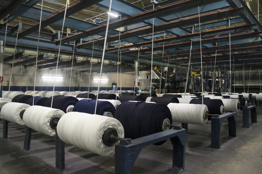Beams of indigo-dyed and natural warp yarn inside the Trion mill
