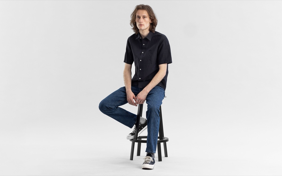 A Todd Shelton selvedge jean and button-up shirt worn on a studio stool